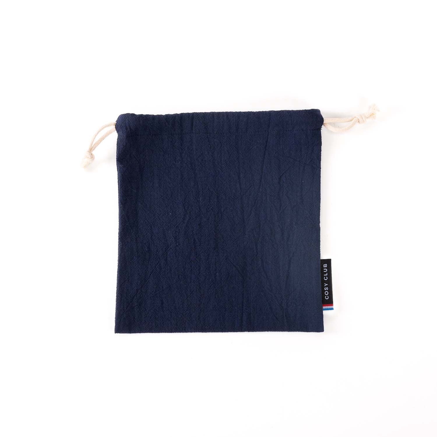 Pochon en tissu, coloris bleu marine, fabriqué en France, idéal pour transporter son passeport et pièce d'identité en voyage ou pour le gouter des enfants à l'école. Présenté sur fond bleu.