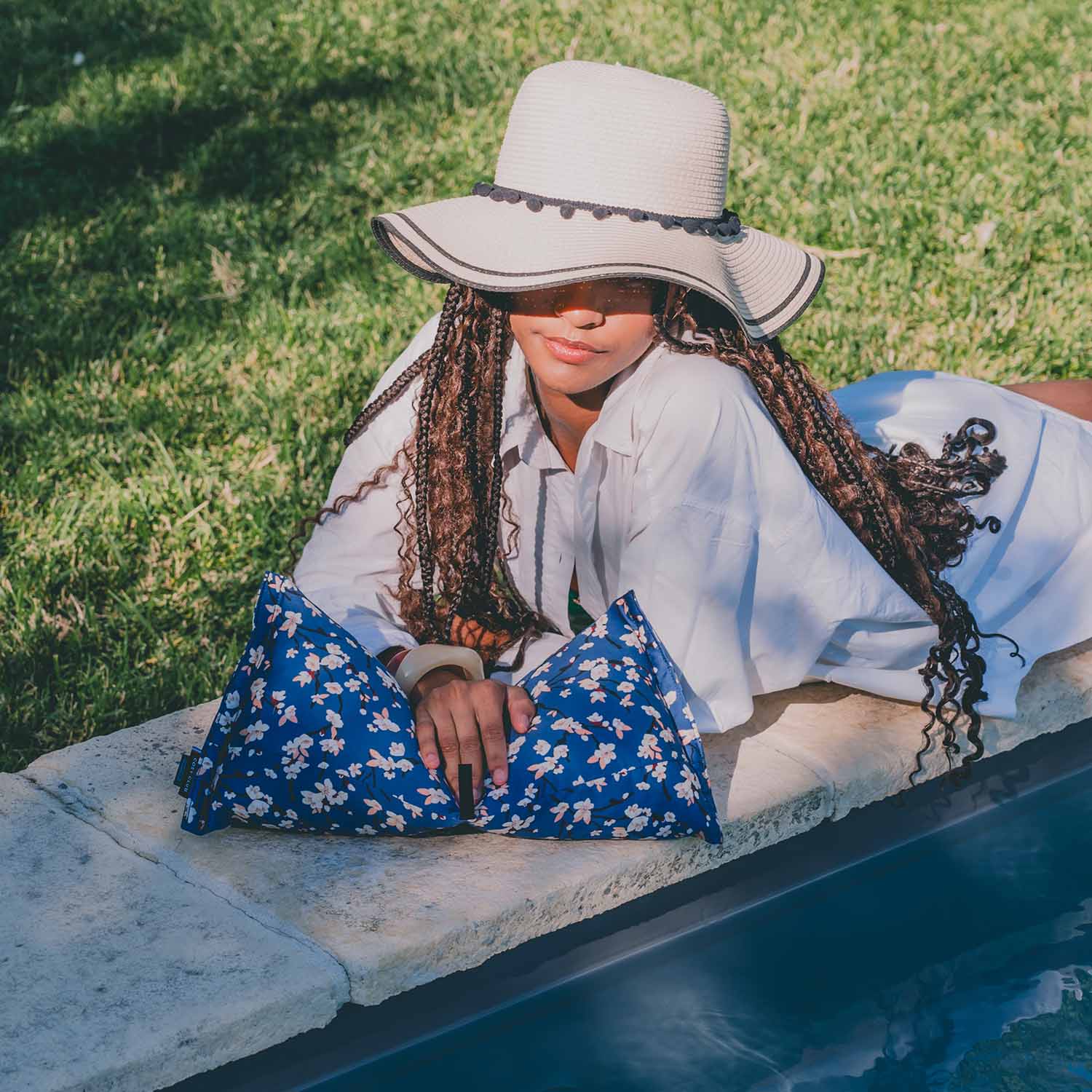 Jeune femme en bord de piscine avec coussin cervical motif fleur de cerisier