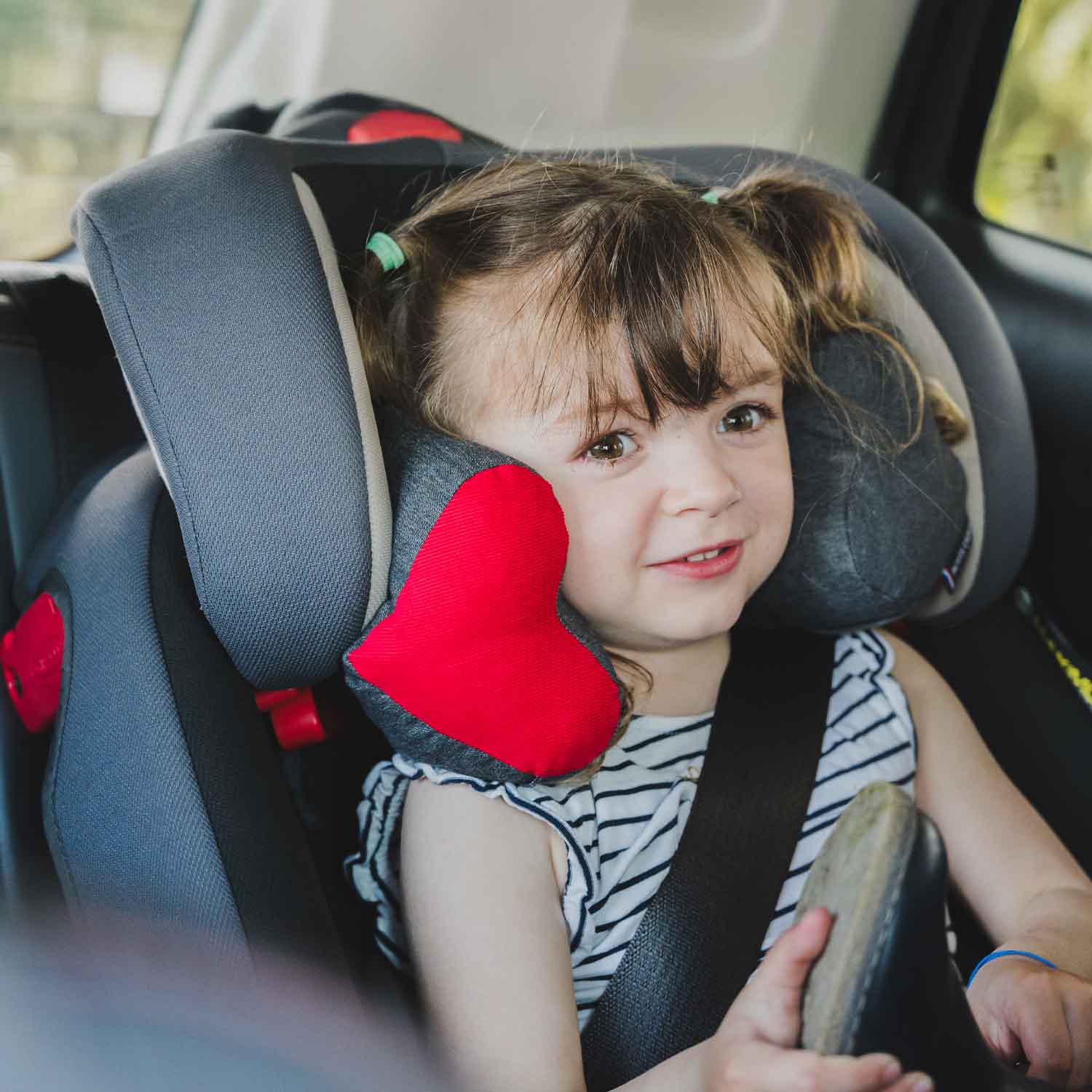 Petite fille avec la tête bien callée dans son siège auto grâce au coussin de poussette et siège auto TEODOR de Cosy Club. Coussin fabriqué en France.
