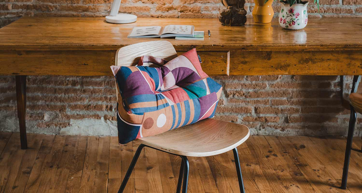 coussin lombaire motif géométrique sur chaise en bois