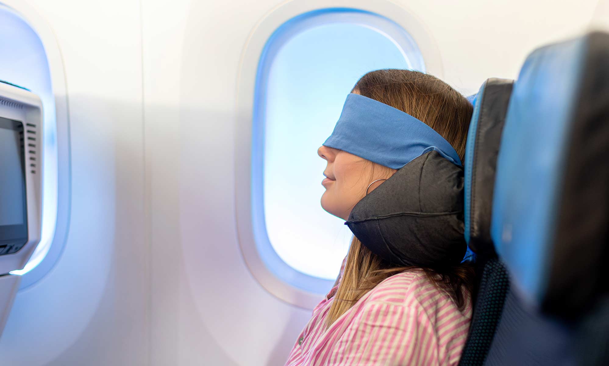 passagère dans l'avion avec coussin de voyage ELLIPSE