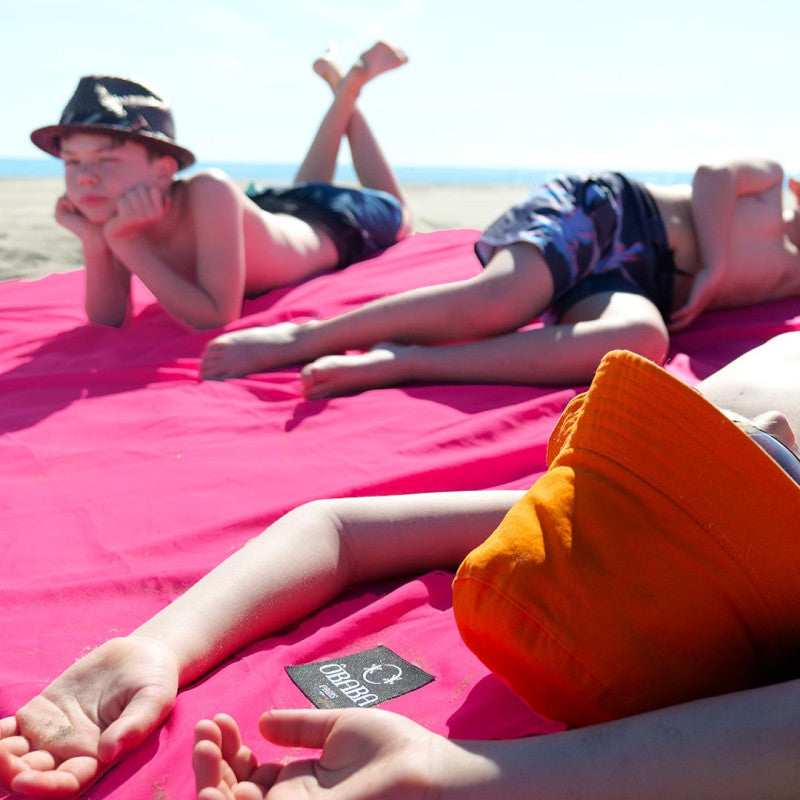 Enfants en vacances allongés sur drap de plage OBABA coloris rose